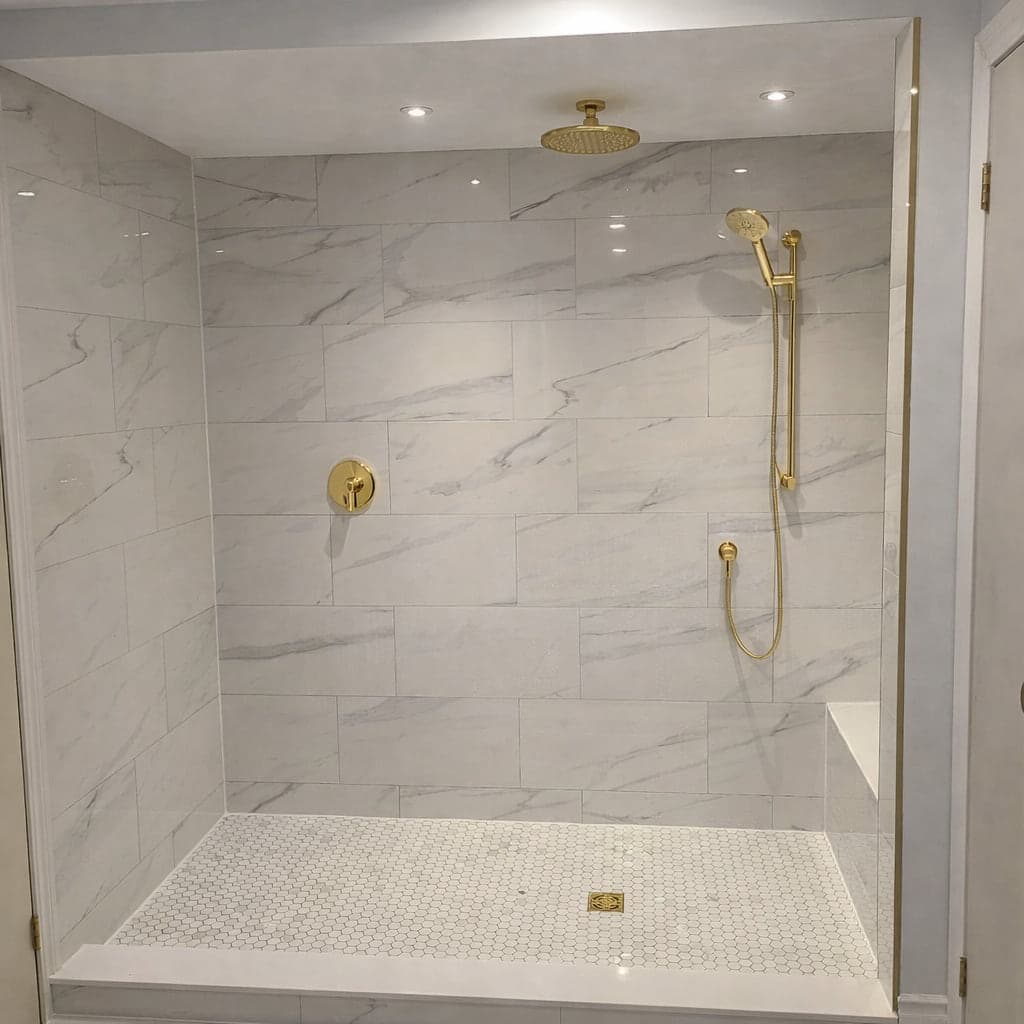 Walk-in shower with light tile, glass enclosure, and dark fixtures