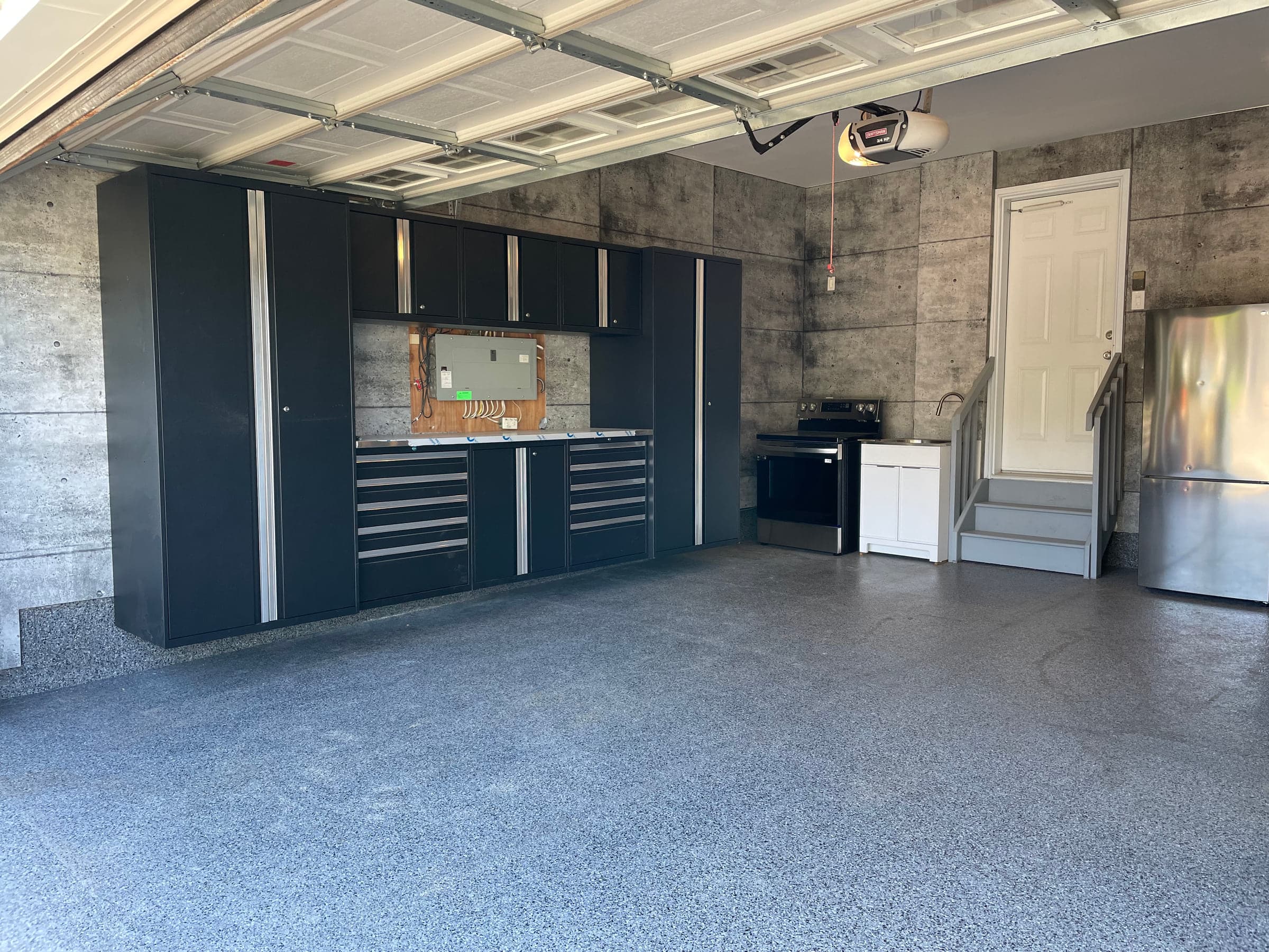 Wide finished garage with wall cabinetry and a coated floor
