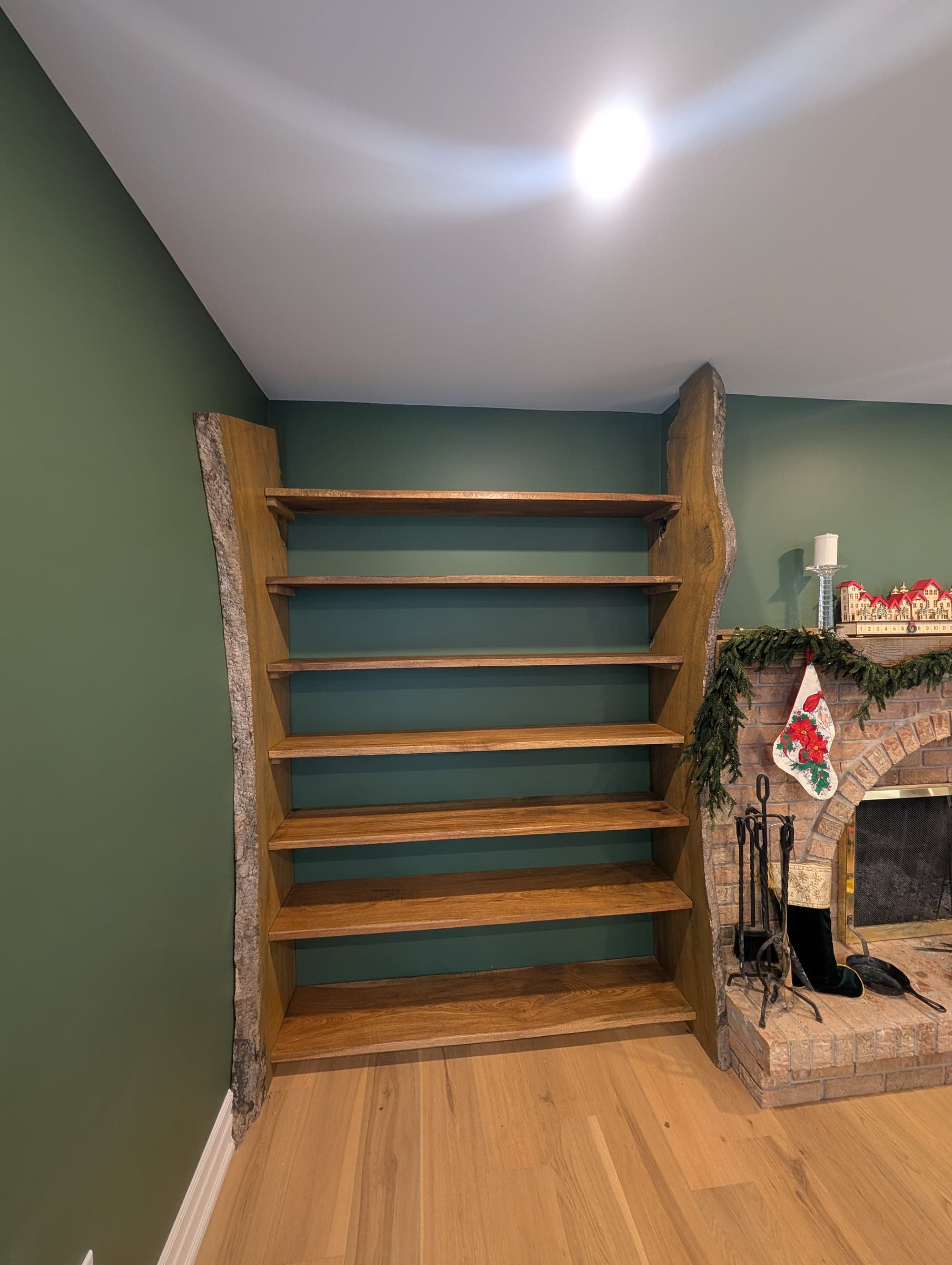Tall open shelving unit against a green wall